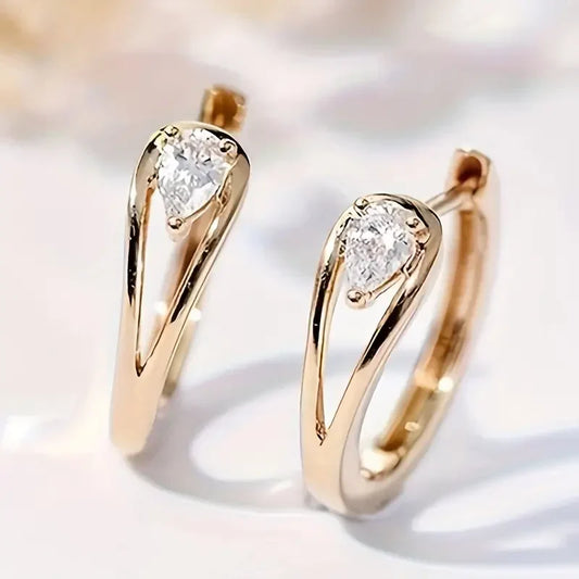 Exquisitos aretes dorados de circonita con forma de lágrima | Oro